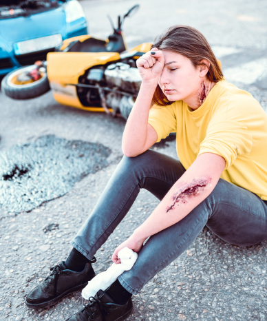 Woman sitting on the road after a motorcycle accident - Mercer Legal Group services