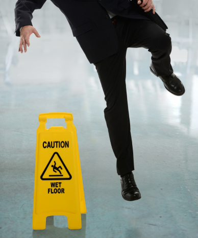 Wet floor caution sign with a person walking by - Mercer Legal Group services