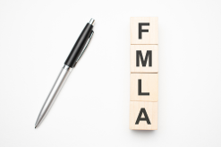 Pen on FMLA book representing workplace rights consultation - Mercer Legal Group services.