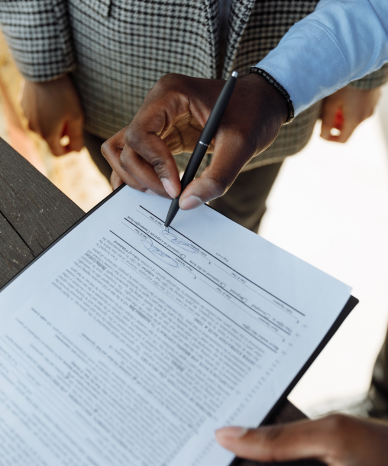 Hands signing legal documents during an employment law consultation - Mercer Legal Group services.