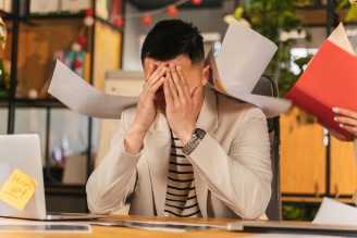 Man stressed while reviewing workplace policies and documentation - Mercer Legal Group services.