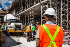 Workers on a construction site discussing legal rights - Mercer Legal Group services.